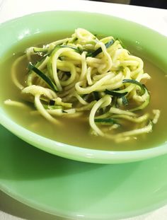 a green bowl filled with noodles and vegetables