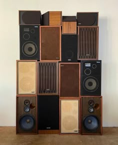 a stack of speakers sitting on top of each other in front of a white wall