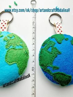 two felt keychains made to look like the earth and measuring tape are shown