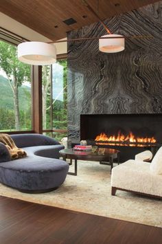 a living room with two couches and a fire place in the middle of it