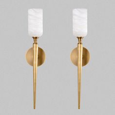 two light wall sconces with white glass shades on each one and gold metal posts