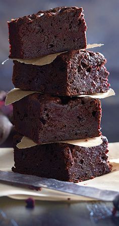 a stack of brownies sitting on top of a cutting board next to a knife