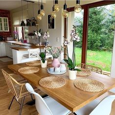 a dining room table with chairs and vases on it