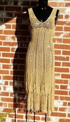 a dress on a mannequin next to a brick wall