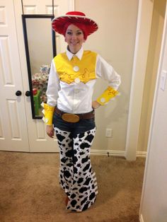 a woman dressed up as a cowgirl standing in front of a door with her hands on her hips