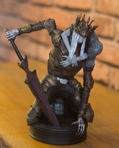 a figurine that is on top of a table with a knife in it