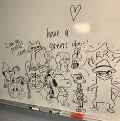 a white board with writing on it and cartoon characters drawn on the wall next to it