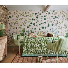 a dining room with green chairs and wallpaper