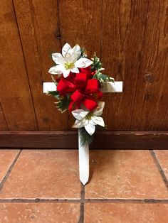 a white cross with red and white flowers