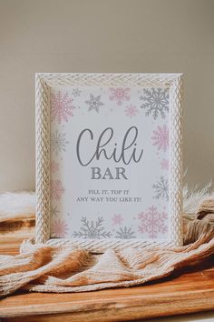 a sign that says chilla bar on top of a wooden table next to a blanket