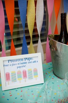 there is a sign on the table that says prosego pops, four glasses of birthday and a plastic cup