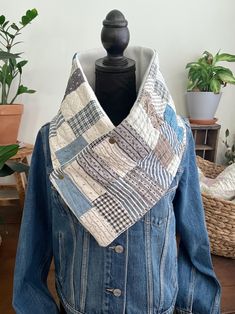 a denim jacket with a patchwork design on the front and back, sitting on top of a mannequin