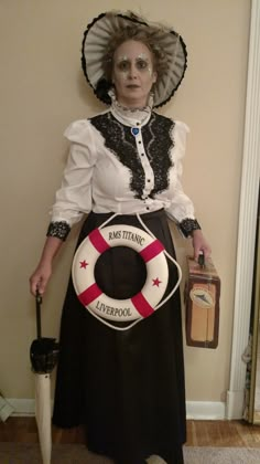 a woman dressed in costume holding an umbrella and wearing a life preserver with the words miss titanic written on it