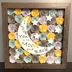 a shadow frame made out of rolled paper with the words love you to the moon and back written on it