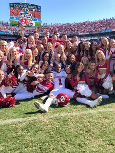 a group of cheerleaders pose for a photo on the field