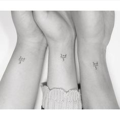 two women with matching tattoos on their arms and wrist are holding each other's hands