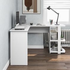 a white desk with a computer on it in a room next to a radiator