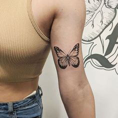 a woman's arm with a butterfly tattoo on the left side of her arm