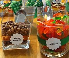 there are jelly beans and carrots in plastic containers on the table with other candies