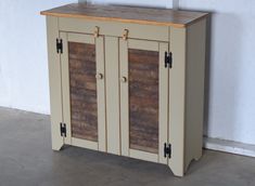 a small cabinet with two doors and wooden top