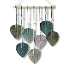 three green and white leaves hanging from a wall