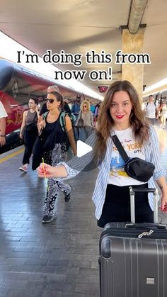 a woman is pulling her luggage through an airport with other people walking by behind her