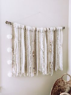 a white wall hanging with tassels and beads