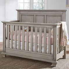 a baby crib is shown with pink and white bedding