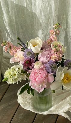 a vase filled with flowers sitting on top of a wooden table