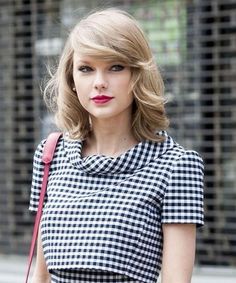 taylor swift is wearing a black and white checkered dress with red lipstick on her lips