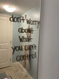 a bathroom mirror that has writing on the side of it and an open door behind it