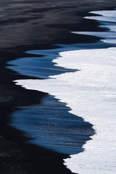 black sand beach with white and blue waves