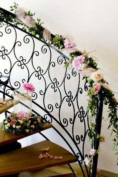 flowers and greenery decorate the railing of a staircase