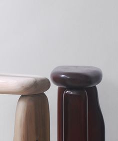 two stools sitting next to each other in front of a white wall and floor