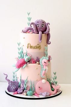 a three tiered cake with an octopus and sea animals on it's side