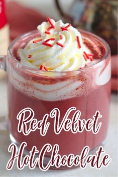 red velvet hot chocolate in a glass mug with whipped cream and sprinkles