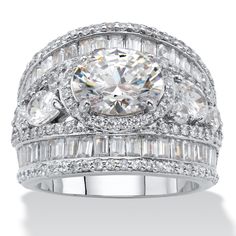 a white gold and diamond ring with three rows of diamonds on the band, surrounded by baguettes