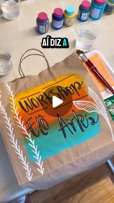 a paper bag with the words we're going to arts on it next to some paintbrushes