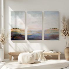 three paintings hanging on the wall in a living room