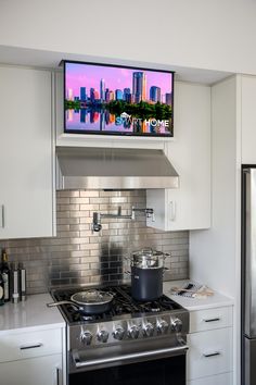 there is a tv above the stove in this kitchen