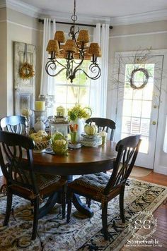 the dining room table is set for christmas dinner with pine cones and evergreen greenery