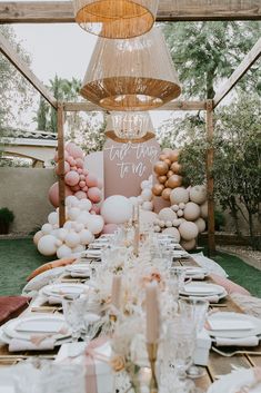 a table set up with balloons, plates and napkins