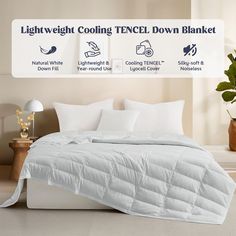 there is a bed with white sheets and pillows on top of it, next to a light weight cooling tencel down blanket