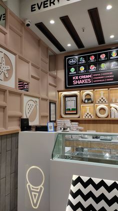 an ice cream shop with lots of display cases and signs on the wall behind it