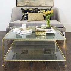 a glass coffee table sitting in front of a couch