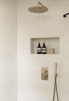 the shower head has two black and white striped vases on it's shelf