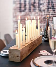 candles are lit on a table with plates and wine glasses