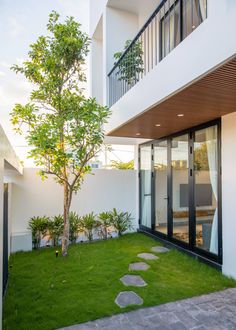 a modern house with grass and trees in the yard