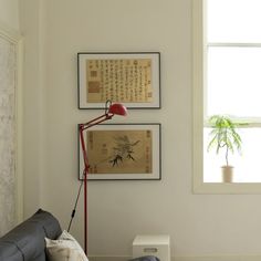 a living room with two framed pictures on the wall and a couch in front of it