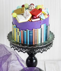 there is a cake decorated with books on the top and purple ribbon around the edge